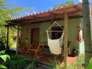 a porch with a hammock on a patio at Casa Raiz 1 Moreré - A 3min da praia in Moreré