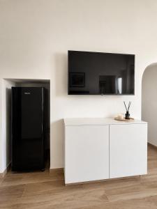 a living room with a black refrigerator and a tv at Domus Regina Sforza in Capurso