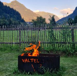 a fire pit in a field with a fence at Haus Valtellina in Sankt Gallenkirch