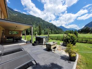 a outdoor patio with a grill and a table and a grill at Haus Valtellina in Sankt Gallenkirch