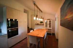a kitchen with a wooden table and white cabinets at Vista Romena in Pratovecchio