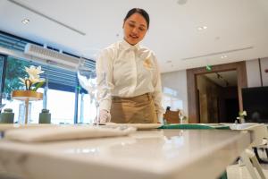 a woman standing behind a table in a room at KH La Maison in Abha