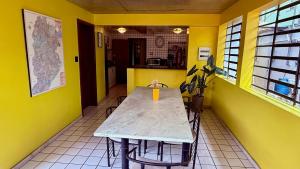 a table in a room with yellow walls at Vila Santê in Belo Horizonte