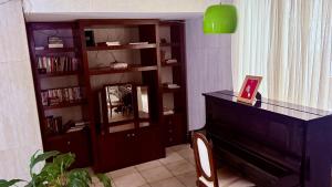 a living room with a piano and a book shelf at Vila Santê in Belo Horizonte