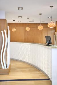 an office lobby with a white and wood wall at Flamboyan Caribe Hotel & Spa in Magaluf +96 photos