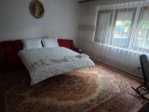 a bedroom with a bed and a window and a rug at Roof - Holiday Home in Gjakove
