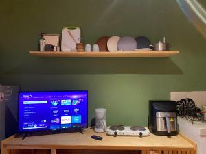 a desk with a computer monitor and a coffee maker at Galerie Guanajuato Centro in Guanajuato