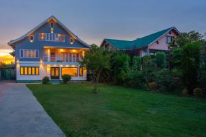 a house with its lights on in a yard at Blume House- 4BHK Holiday Home with Kitchen & Garden in Srinagar