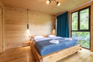 a bedroom with a bed in a wooden room at Cozy Cottages in Mestia