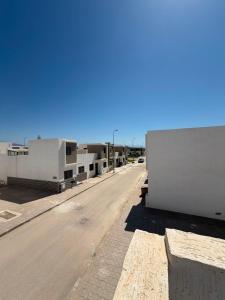 an empty street next to a white building at Mini Villa Azur - Bord de Mer in Driouch