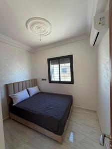 a bedroom with a bed in a room with a window at Mini Villa Azur - Bord de Mer in Driouch