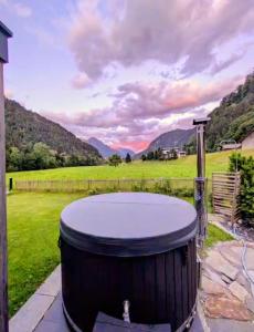 a hot tub in a yard with mountains in the background at Haus Valtellina in Sankt Gallenkirch