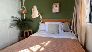 a bed in a bedroom with a green wall at Galerie Guanajuato Centro in Guanajuato