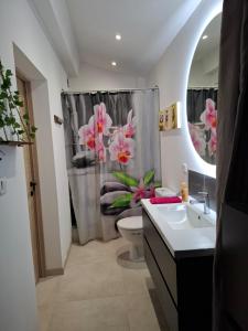 a bathroom with a toilet and a shower curtain with flowers at escapade coeur provence in La Celle