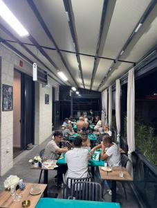 a group of people sitting at tables in a restaurant at Hostel Vento in Bar