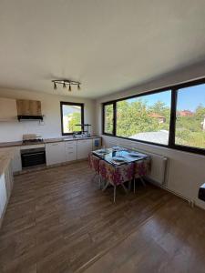 a large kitchen with a table and some windows at Rose Cozy in Snagov +9 photos