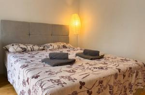 a bedroom with a bed with two pillows on it at Spacious Rooms Near Center in Ljubljana