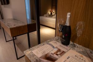a bottle of wine sitting on a table with a box and glasses at South Inn Marina Hotel in Vlorë