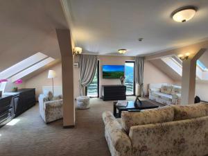 a living room with two couches and a tv at Pensiunea Toscana in Braşov