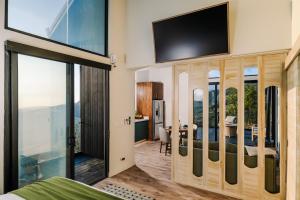a bedroom with a tv on the wall and a bed at Lakay Monteverde with Heated Pool, Golf Cart and Breakfast in Monteverde Costa Rica