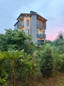 a building on top of a hill with trees at Villa Feel Georgia in Batumi
