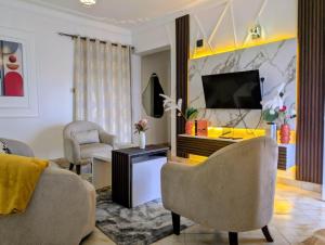 a living room with a couch and a tv at LYZ HOMES Ltd in Kampala
