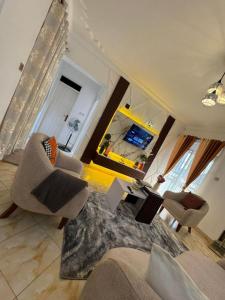 a living room with a couch and chairs and a mirror at LYZ HOMES Ltd in Kampala