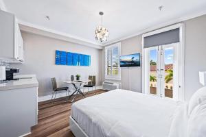 a white room with a bed and a table with a dining room at 1BR Retreat with Private Terrace in Palm Beach