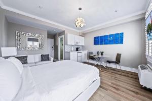 a bedroom with a large white bed and a kitchen at 1BR Retreat with Private Terrace in Palm Beach