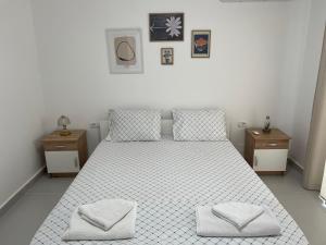 a bedroom with a white bed with two night stands at FAME Apartment - Permet in Përmet