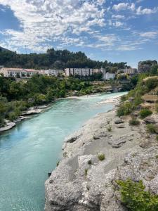 a view of a river with buildings in the background at FAME Apartment - Permet in Përmet