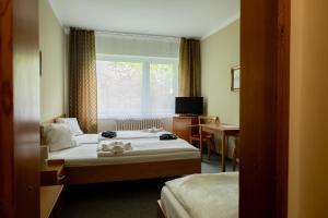a hotel room with two beds and a window at Penzion Hubert Františkovy Lázně in Františkovy Lázně