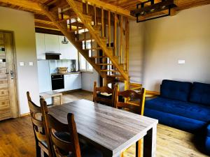 a living room with a table and a blue couch at Domek nad Oczkiem Wodnym in Giżycko
