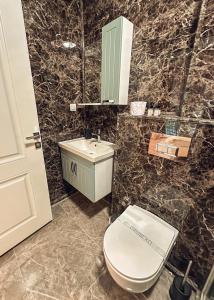 a bathroom with a toilet and a sink and a mirror at Çamra Otel in Armutlu +9 photos