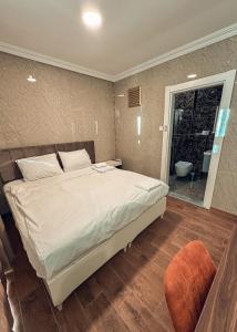 a bedroom with a large bed and a bathroom at Çamra Otel in Armutlu