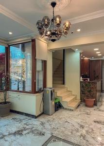 a lobby with a staircase and a chandelier at Çamra Otel in Armutlu