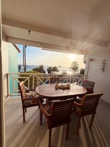 a wooden table and chairs on a balcony at Bonaire Oceanfront Apartments in Kralendijk