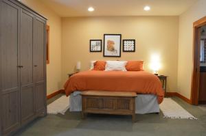 a bedroom with a bed with an orange bedspread at Corbin B&B in Corvallis