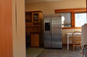 a kitchen with a stainless steel refrigerator and a table at Corbin B&B in Corvallis +6 photos