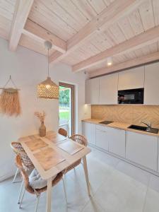 a kitchen and dining room with a wooden table and chairs at Morze Las in Ustka