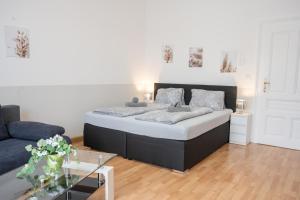 a bedroom with a bed and a living room with a couch at Paky Appartements 00210 in Vienna