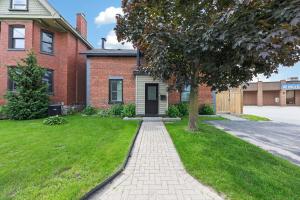 a brick house with a tree and a sidewalk at The 1883 Century Flat Suite in Collingwood