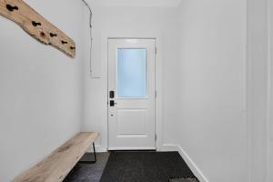 a hallway with a white door and a wooden bench at The 1883 Century Flat Suite in Collingwood