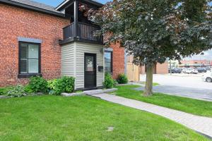 a brick house with a black door and a tree at The 1883 Century Flat Suite in Collingwood