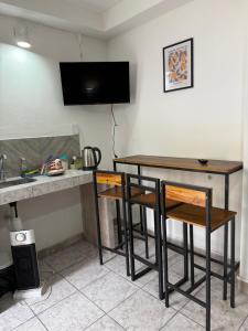a kitchen with a table and two chairs and a tv at Casa del Arte in Salta