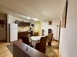 a kitchen and dining room with a table and chairs at Stejarului Apartment in Floreşti