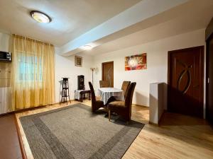 a living room with a table and chairs at Stejarului Apartment in Floreşti