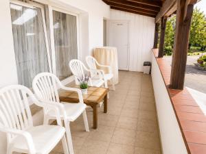 a porch with white chairs and a wooden table at Pension Reiter in Blomberg