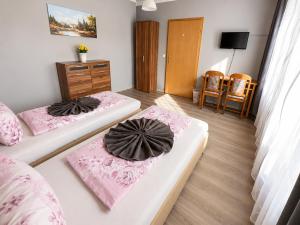 a room with two beds and a dresser in it at Pension Reiter in Blomberg