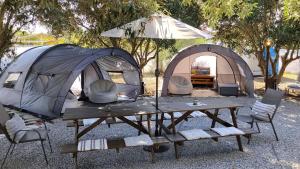 a tent and a picnic table with chairs and a picnic table sidx sidx at Summer IGLOO by the sea in COCOland in Pálioura